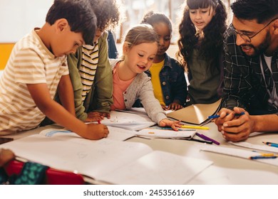 Group of children doing an art project with their teacher. Elementary school students enjoy drawing using colouring pencils. Creativity as part of early child development. - Powered by Shutterstock