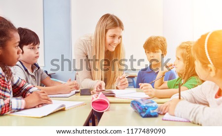 Group of children doing homework together with a teacher in a full-time school