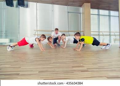 Group Of Children Doing Kids Gymnastics In Gym With Nursery Teacher