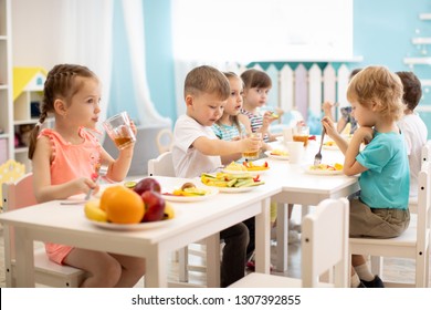 Group Of Children Eating Healthy Food In Day Care Centre