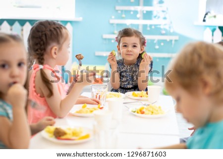 Group of children eating healthy food in kindergarten