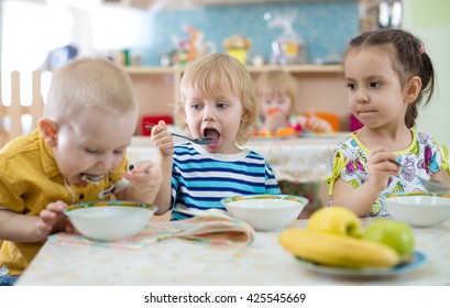 group of children eating from plates in day care centre