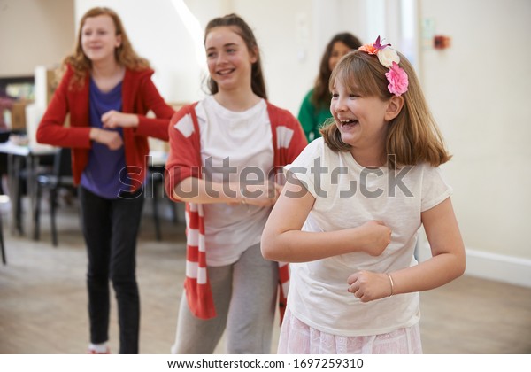 Group Of Children Enjoying Dance Lesson At Stage\
School Together
