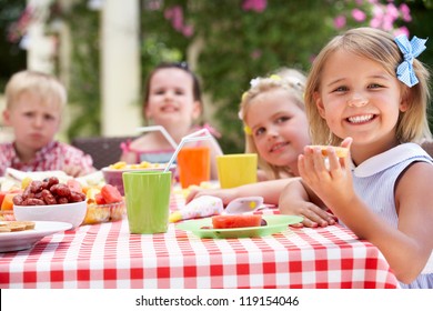 Group Of Children Enjoying Outdoor Tea Party