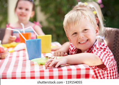 Group Of Children Enjoying Outdoor Tea Party