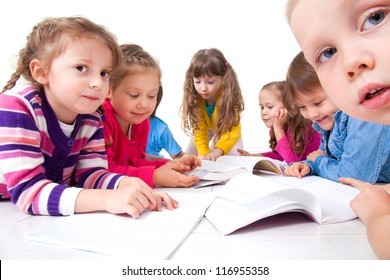 Group of children enjoying reading together - Shutterstock ID 116955358