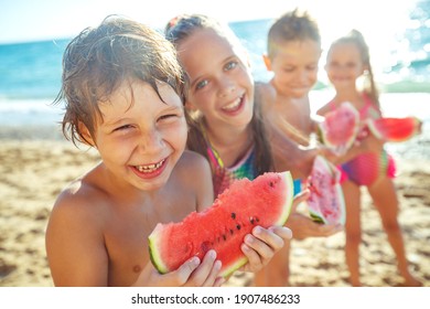 A group of children have fun playing at the sea. Children in bathing suits. Friends holding hands and running on the beach. High quality photo. - Powered by Shutterstock