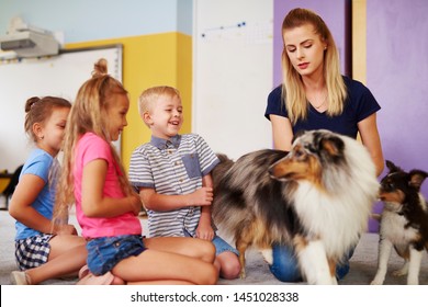 Group Of Children Having Fun With Dog During Therapy