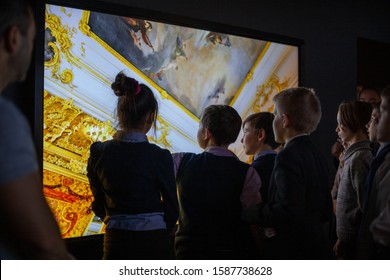 A Group Of Children In An A History Museum Visiting The Exhibition, Interactive Learning. Children Use An Interactive Touchscreen Display. St. Petersburg, Russia, Historical Park, November 24, 2019