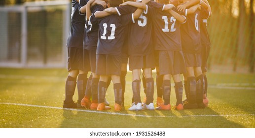 Group of children huddling with coach. Summer sunset at the stadium in the background. Youth soccer football team group photo. Happy boys soccer players kicking tournament. School boys in blue jerseys - Powered by Shutterstock