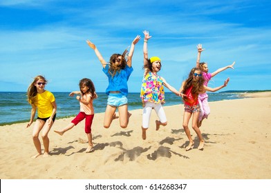 A group of children jumping together on the beach