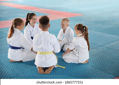 Group Of Children In Kimono Sitting On Tatami After Karate Practice