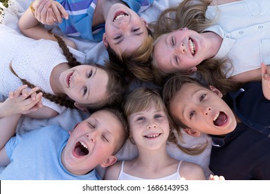 A Group Of Children Are Lying On The Grass And Laughing