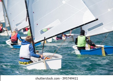 Group Of Children On Sailing Boats Competing In The Regatta At Sea