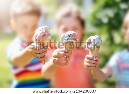 Group of children in the park eating cold ice cream. Concept of friendship and family relationship.