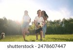 A group of children playing with a ball. Fun summer soccer concept. A family of children are running and playing with a ball. A group of children playing ball with a lifestyle family running around.