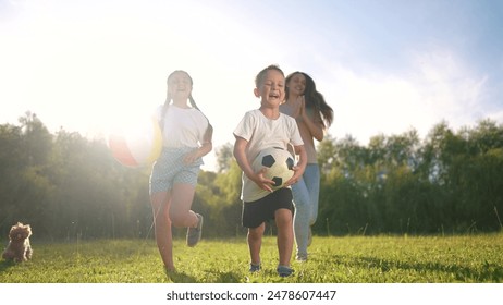 A group of children playing with a ball. Fun summer soccer concept. A family of children are running and playing with a ball. A group of children playing ball with a lifestyle family running around. - Powered by Shutterstock