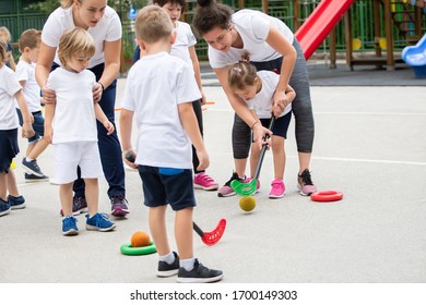 Group of children playing hockey within polygon.  Sport school. Coach helping - Powered by Shutterstock