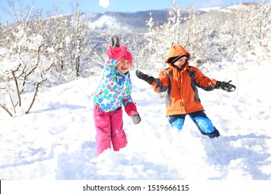 Group Of Children Playing On Snow In Winter Time