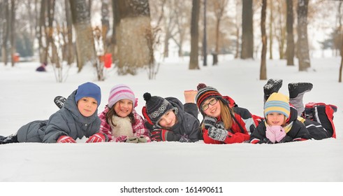 Group Of Children Playing On Snow In Winter Time