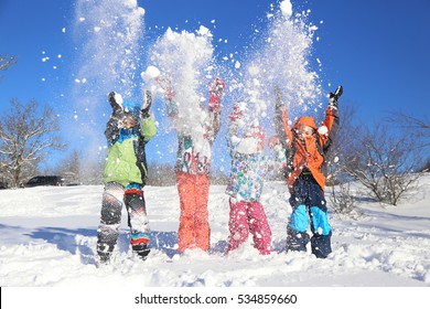 Group of children playing on snow in winter time