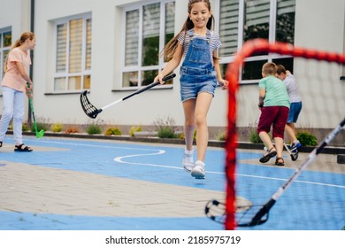 Group of children playing street hockey on a city holiday on the playground