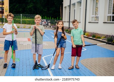 Group of children playing street hockey on a city holiday on the playground - Powered by Shutterstock