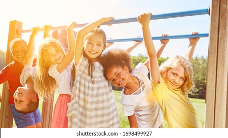Group of children plays together at climbing frame on a playground in the summer