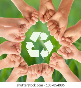 Group of children putting hands together and recycling symbol against blurred background, closeup - Shutterstock ID 1357854086