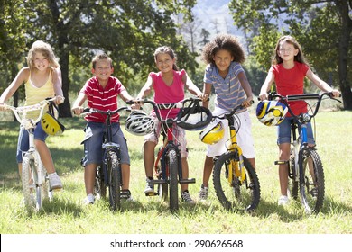 Group Of Children Riding Bikes In Countryside