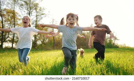 Group Of Children Running In The Park. Happy Family Baby Kid Dream Concept. Kindergarten. Children Hands To The Sides Play Pilots Plane Run On Sun The Grass In The Summer In The Park