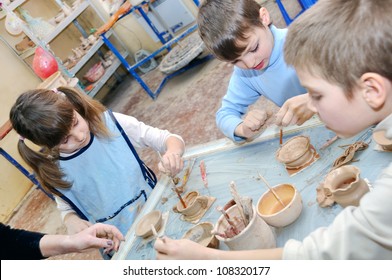 group of children shaping clay at the pottery studio - Powered by Shutterstock