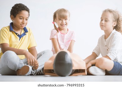 Group Of Children Sitting On The Floor During First Aid Training At School