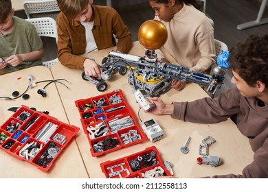 Group of children sitting at the table with constructor and projecting electric robots at the lesson - Powered by Shutterstock - Get 15% off with code: PIKWIZARD15