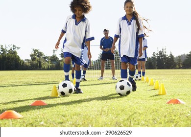 Group Of Children In Soccer Team Having Training With Coach