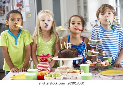 Group Of Children Standing By Table Laid With Birthday Party Food