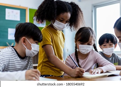 A group of Children students wearing medical masks in the classroom. An Asian woman teacher and students were discussing the lesson. Concept of prevention of the coronavirus outbreak And new normal