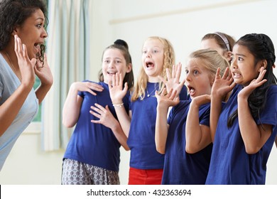 Group Of Children With Teacher Enjoying Drama Class Together