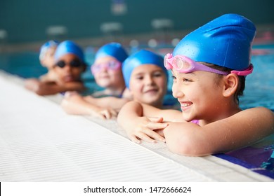 Group Of Children In Water At Edge Of Pool Waiting For Swimming Lesson