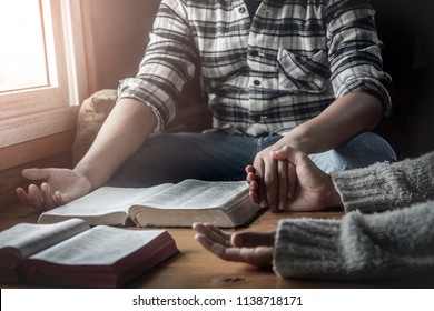 group of christianity sitting with open holy bible and praying to God together.