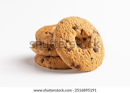 Group of classic shortbread biscuits with chocolate chips, circular biscuits with a hole in the center, typically crumbly and slightly golden on the surface, made with simple ingredients like flour, b