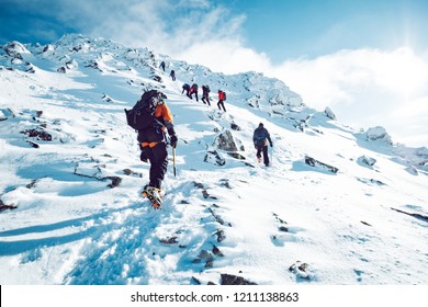 A group of climbers ascending a mountain in winter - Shutterstock ID 1211138863