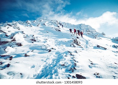 A Group Of Climbers Ascending A Mountain In Winter