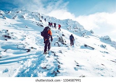 A group of climbers ascending a mountain in winter - Shutterstock ID 1334587991