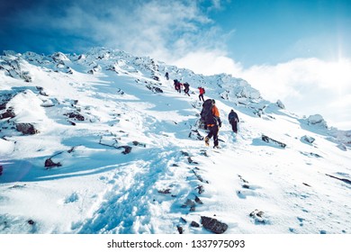 A group of climbers ascending a mountain in winter - Shutterstock ID 1337975093