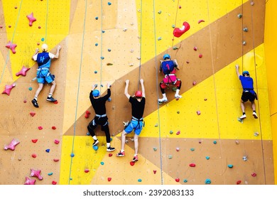 A group of climbers athletes compete in a high-speed ascent of a steep wall. Sports events at the climbing wall. Unrecognizable person - Powered by Shutterstock