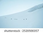 Group of climbers early morning summit push climb on icy ridge of Mount kazbek peak in Georgia. Mount Kazbek or Mount Kazbegi is dormant stratovolcano - major mountains of the Caucasus