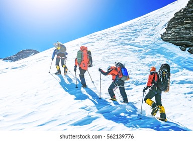 Group of climbers reaches the top of mountain peak. Climbing and mountaineering sport. Teamwork concept.
 - Shutterstock ID 562139776