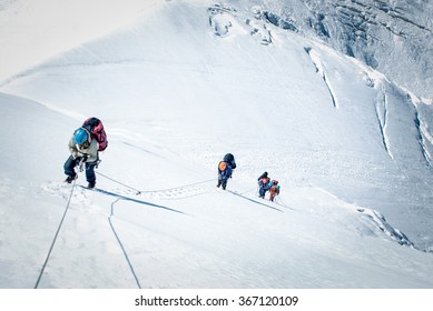 A Group Of Climbers Reaching The Summit