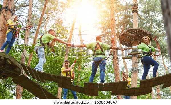 Group climbing together in the climbing forest as a\
team building event